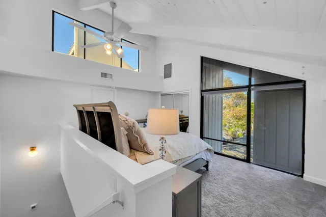 a bedroom with a bed and large windows