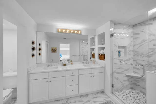 a en suite bathroom with a granite countertop sink mirror and shower