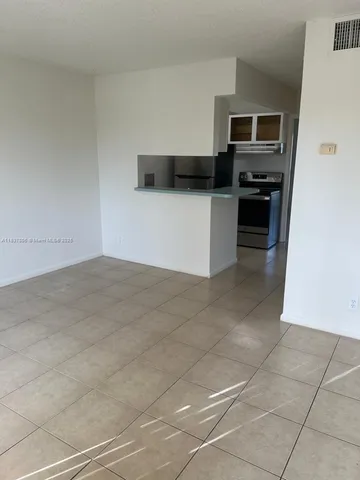 a view of a kitchen with refrigerator and door
