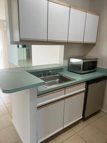 a kitchen with a sink a stove and cabinets