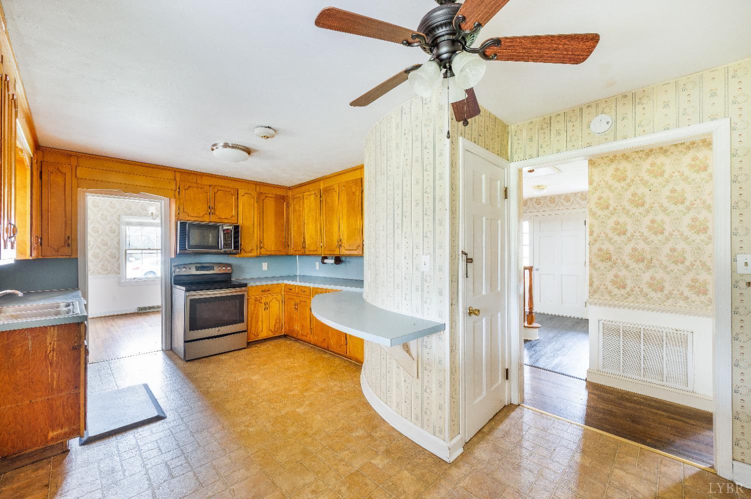 733 Oakville Road Appomattox, VA 24522 - Photo 22 of 52 a large kitchen with stainless steel appliances a stove a refrigerator and a view of living room