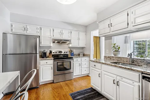 a kitchen with cabinets stainless steel appliances a sink and a window