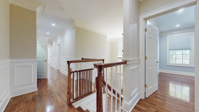 a view of a hallway with wooden floor and staircase