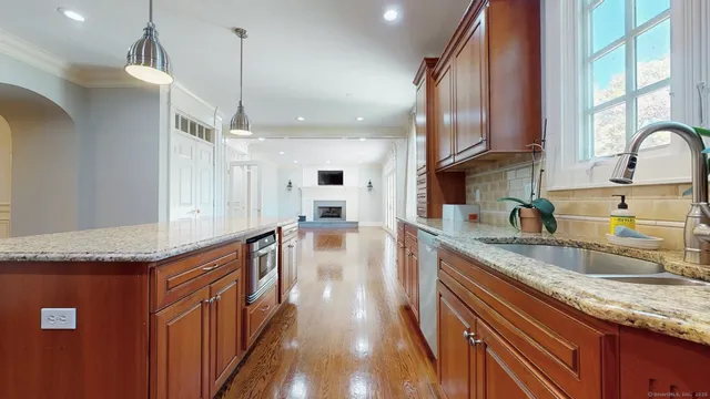 a kitchen with granite countertop a sink a counter space appliances and cabinets