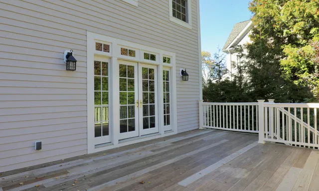a view of a house with a big yard plants and large trees