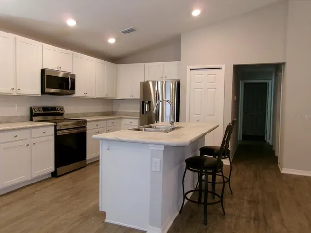 a kitchen with kitchen island granite countertop a sink and stainless steel appliances