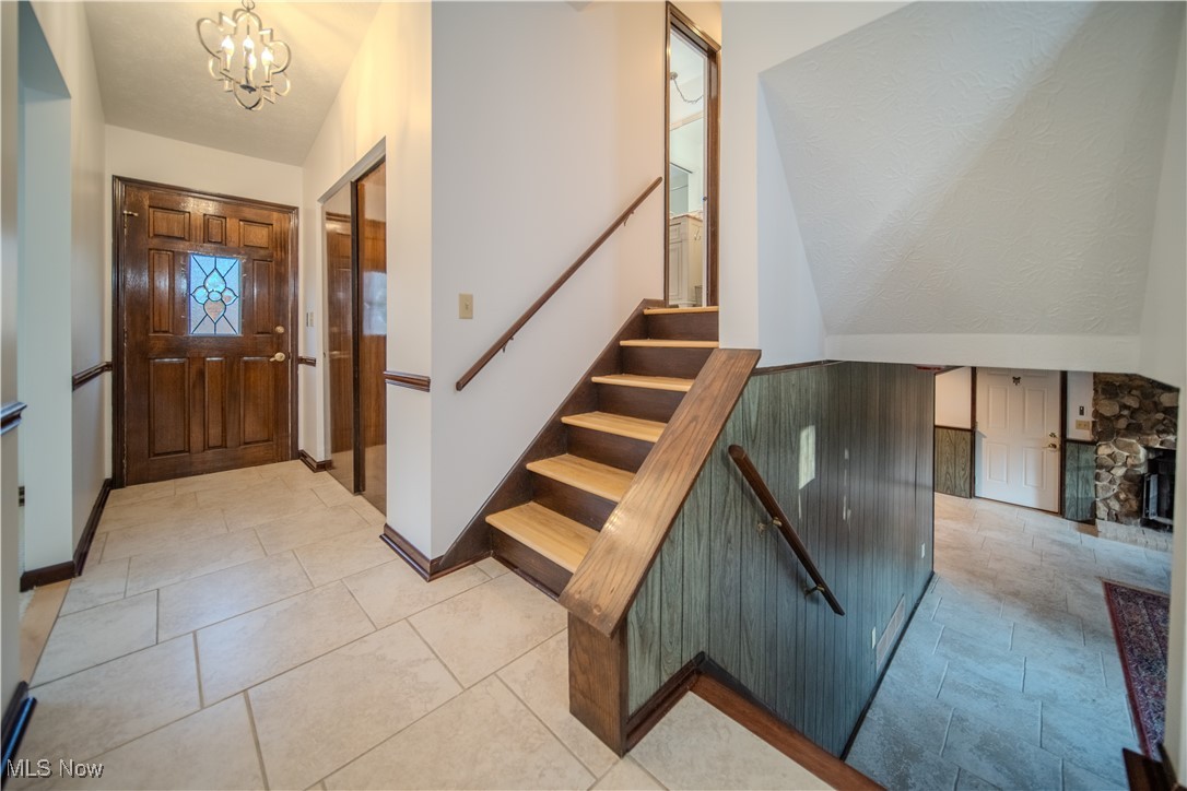 698 Albert Horning Road Atwater, OH 44201 - Photo 27 of 40 Entryway featuring stairs, a chandelier, and light tile patterned flooring
