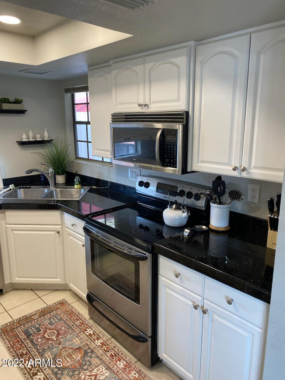 10017 East Mountain View Road, Unit 2058 Scottsdale, AZ 85258 - Photo 13 of 37 a kitchen with stainless steel appliances granite countertop a sink a stove a microwave and cabinets