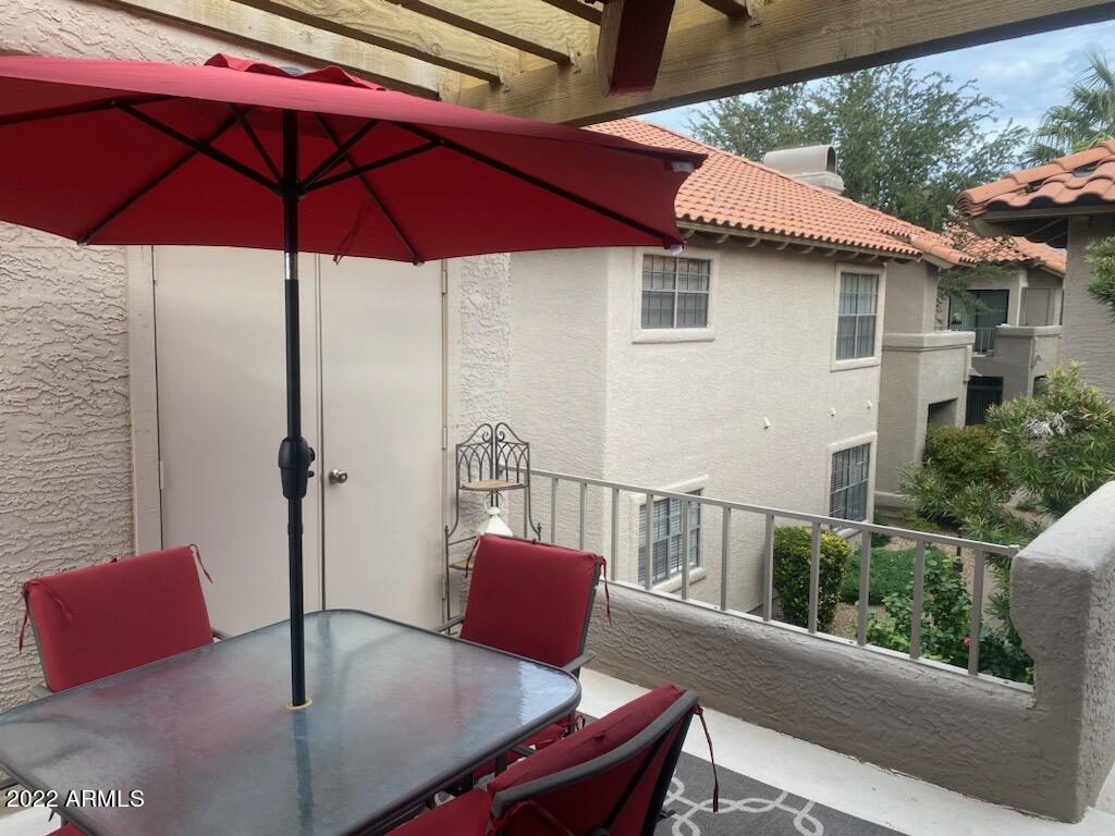 10017 East Mountain View Road, Unit 2058 Scottsdale, AZ 85258 - Photo 10 of 37 a view of balcony with a table and chairs under an umbrella