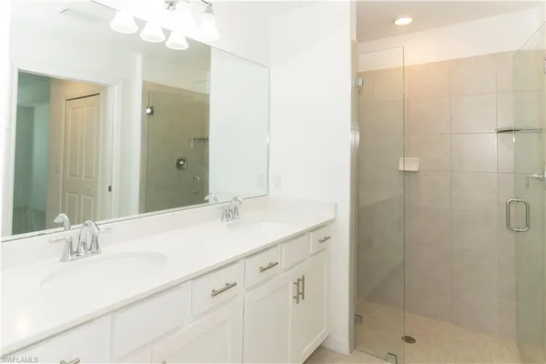 a bathroom with a shower sink and mirror