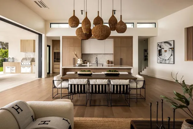 a living room with furniture kitchen view and a large window