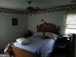 19252 Fort Valley Road Strasburg, VA 22657 - Photo 8 of 11 a bedroom with a bed and a chandelier