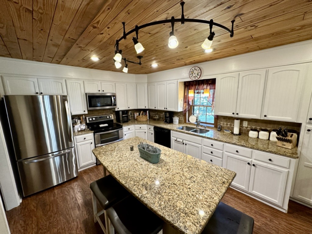 188 Link Road Cottontown, TN 37048 - Photo 6 of 45 a kitchen with granite countertop stainless steel appliances a refrigerator a stove a sink a center island and chairs