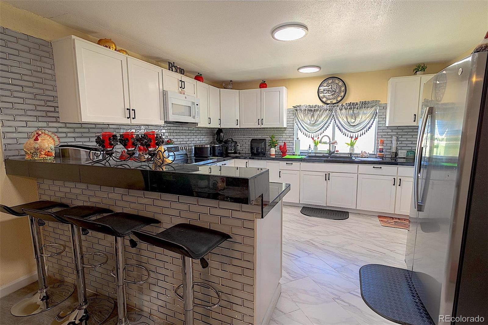 3415 Wiesner Road Calhan, CO 80808 - Photo 18 of 33 a kitchen with granite countertop a sink cabinets and stainless steel appliances