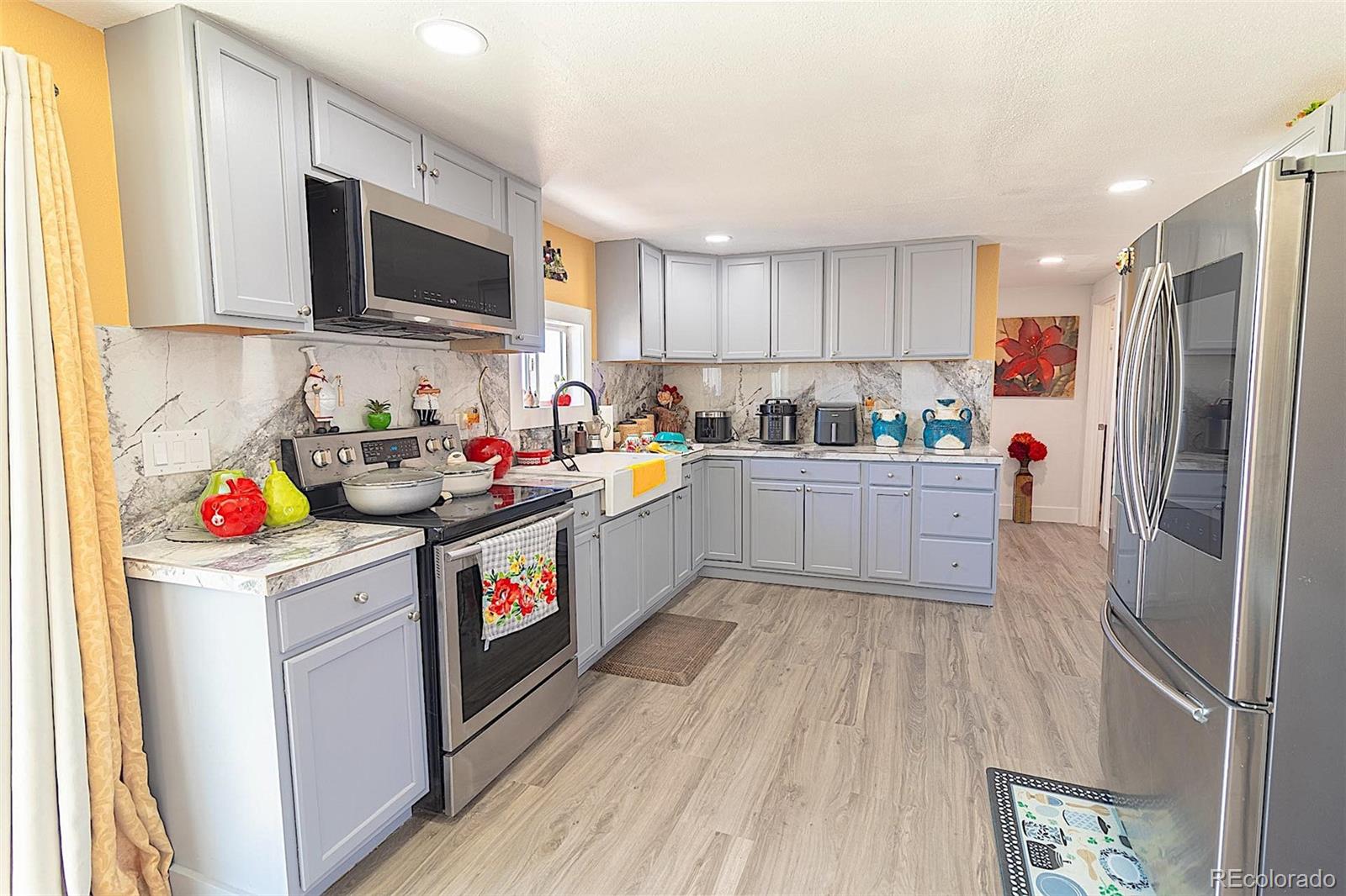 3415 Wiesner Road Calhan, CO 80808 - Photo 23 of 33 a open kitchen with stainless steel appliances granite countertop a stove top oven a sink dishwasher and a microwave with wooden floor