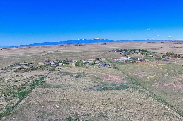 a kitchen with stainless steel appliances granite countertop a table chairs in it and wooden floors