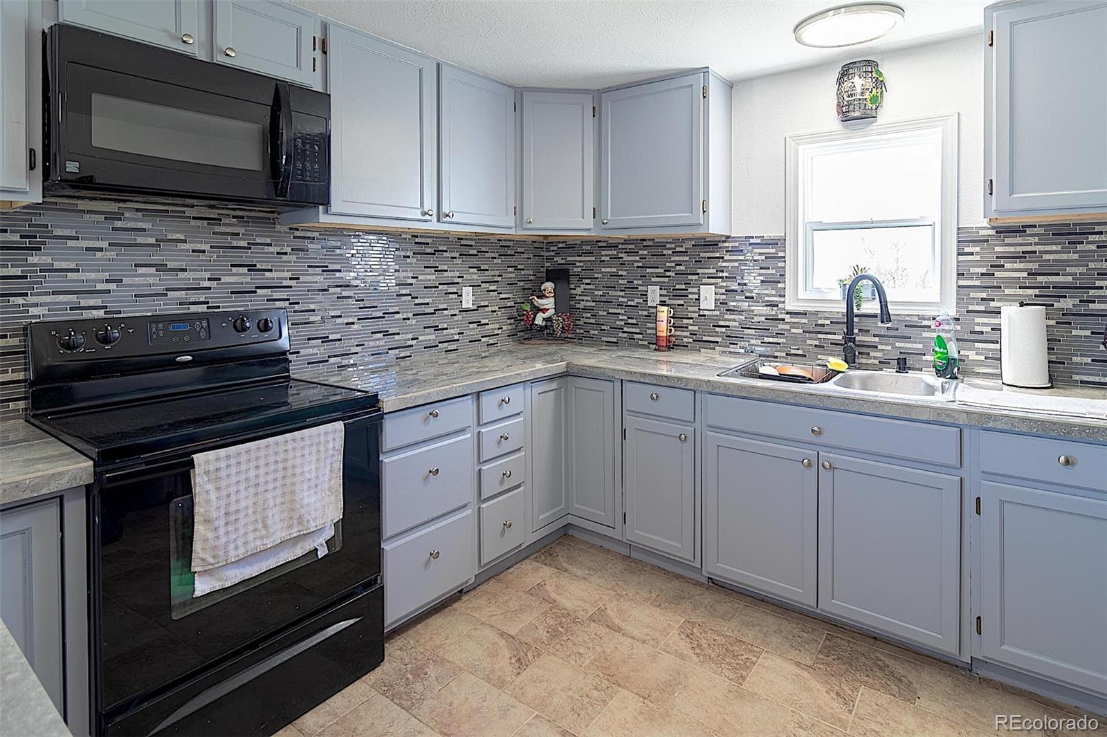 3415 Wiesner Road Calhan, CO 80808 - Photo 7 of 33 a kitchen with stainless steel appliances granite countertop a stove microwave and sink