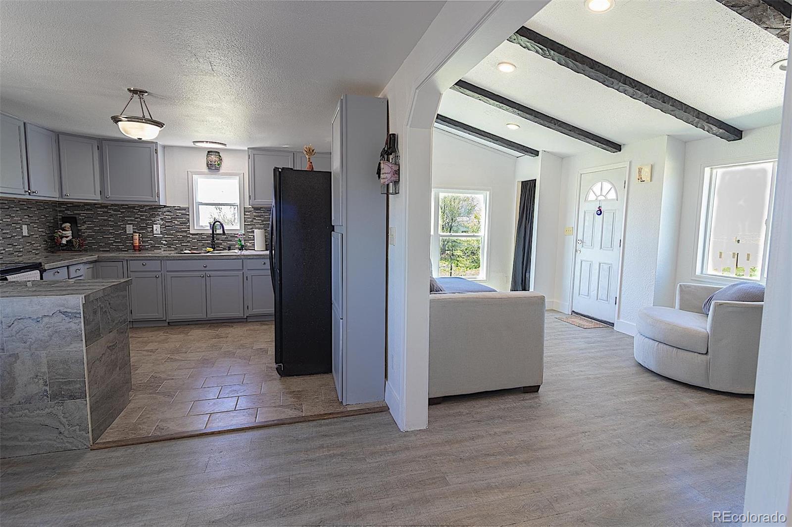 3415 Wiesner Road Calhan, CO 80808 - Photo 8 of 33 a kitchen with kitchen island white cabinets and refrigerator