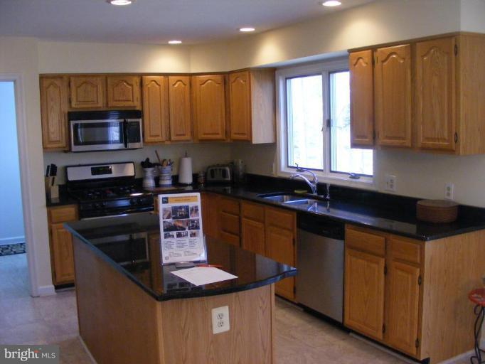 1219 Providence Road Towson, MD 21286 - Photo 22 of 27 a kitchen with stainless steel appliances granite countertop a sink stove and microwave