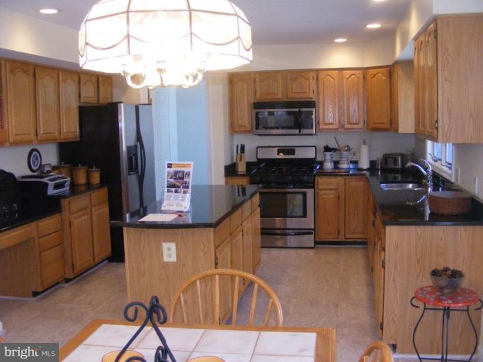 1219 Providence Road Towson, MD 21286 - Photo 24 of 27 a kitchen with stainless steel appliances granite countertop a refrigerator a stove top oven a sink and dishwasher