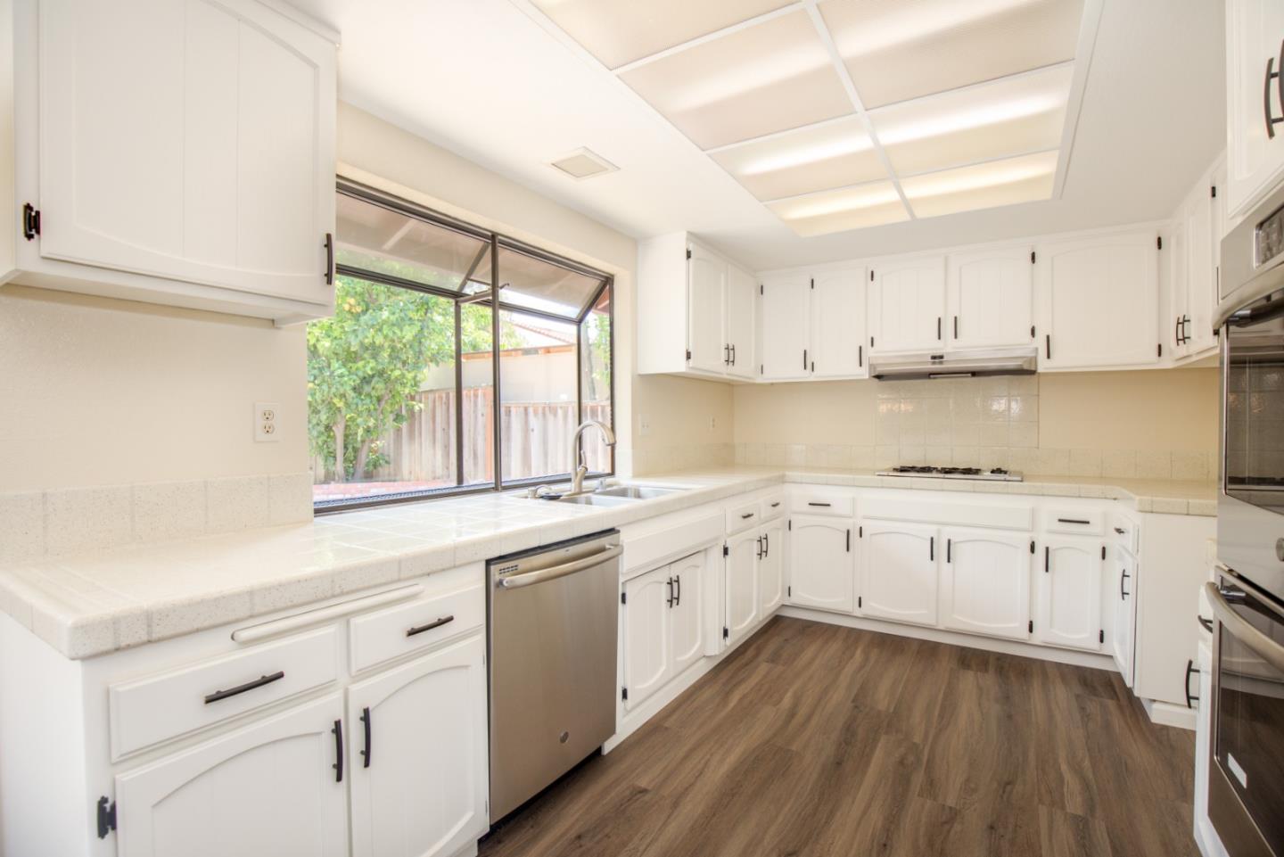 2774 Boncheff Drive San Jose, CA 95133 - Photo 11 of 38 a kitchen with granite countertop white cabinets white appliances a sink and a window