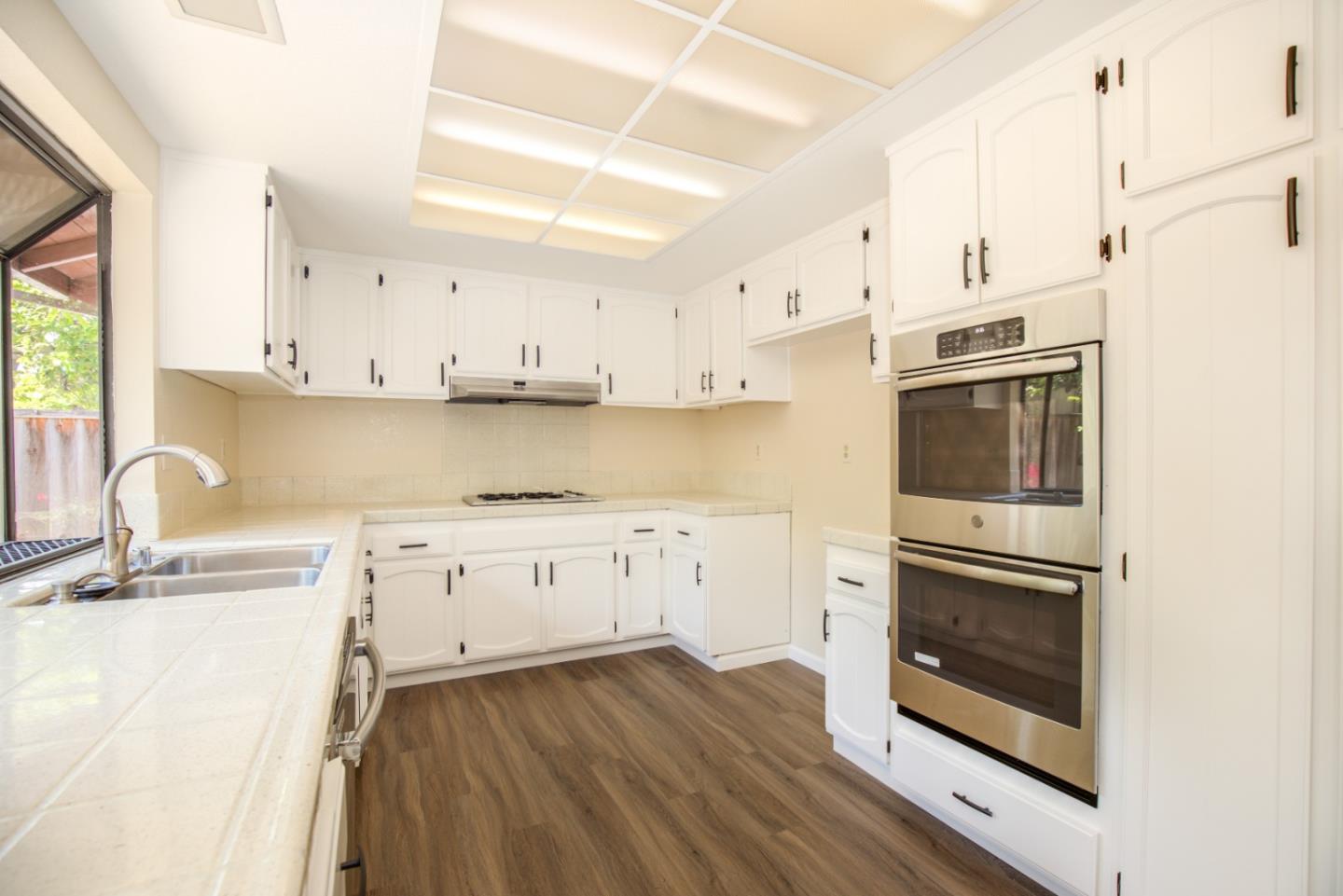 2774 Boncheff Drive San Jose, CA 95133 - Photo 12 of 38 a kitchen with stainless steel appliances granite countertop a stove a sink and white cabinets