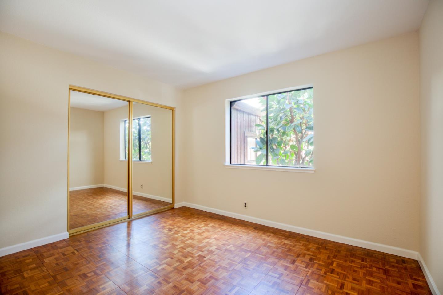 2774 Boncheff Drive San Jose, CA 95133 - Photo 18 of 38 an empty room with wooden floor mirror and windows
