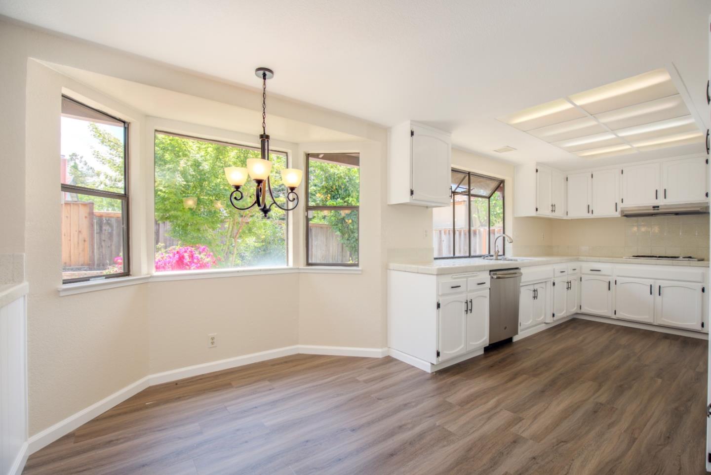 2774 Boncheff Drive San Jose, CA 95133 - Photo 10 of 38 a kitchen with wooden floors white cabinets and a window