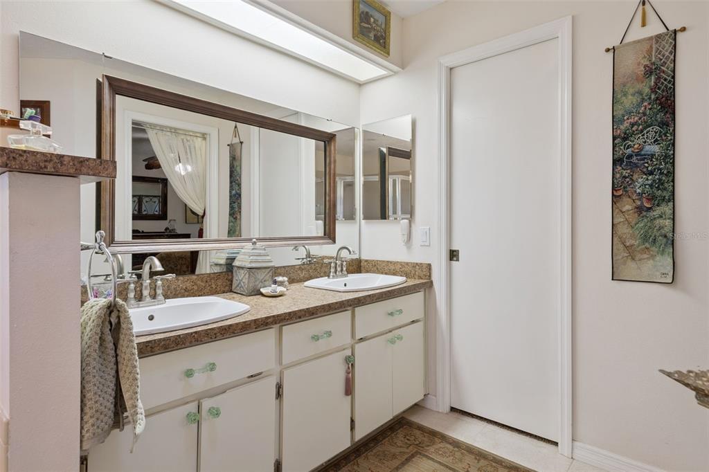 26600 Racquet Circle Leesburg, FL 34748 - Photo 31 of 80 a bathroom with a double vanity sink and mirror