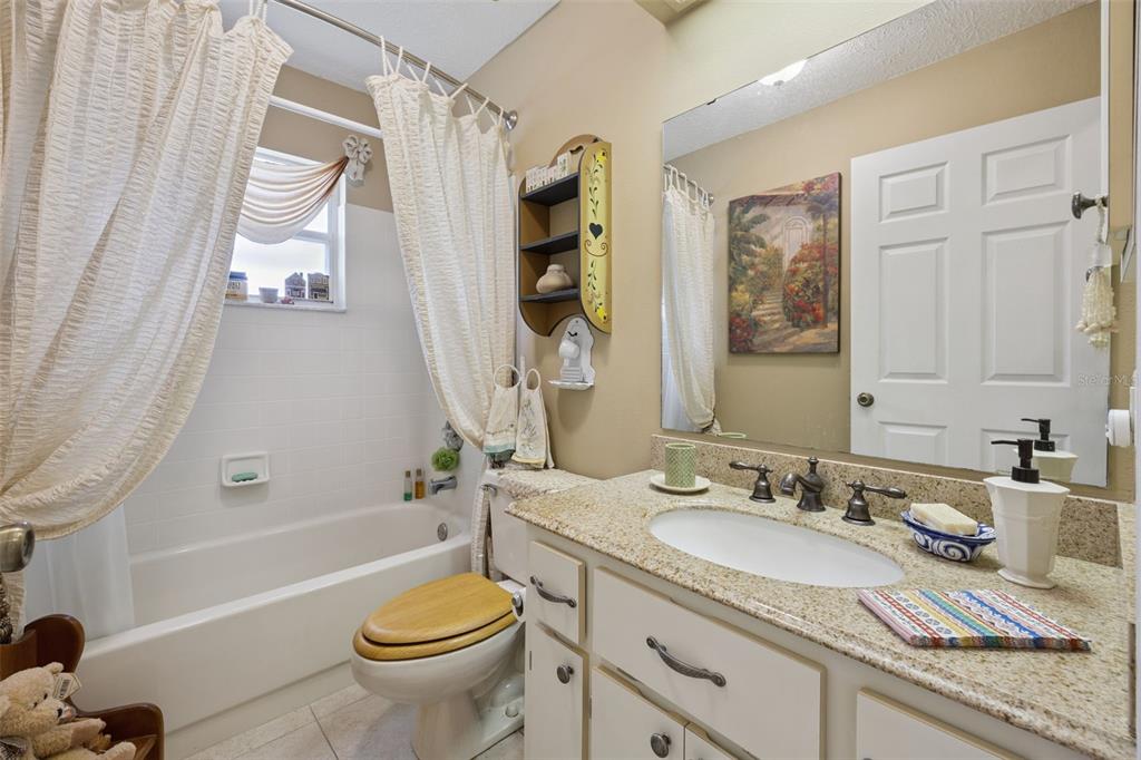 26600 Racquet Circle Leesburg, FL 34748 - Photo 34 of 80 a bathroom with a granite countertop toilet sink and mirror