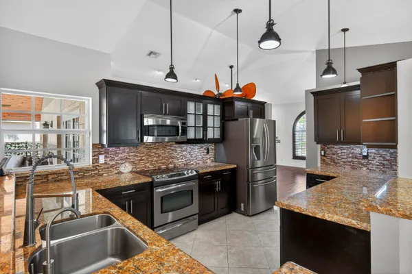 a kitchen with stainless steel appliances granite countertop a sink and a stove