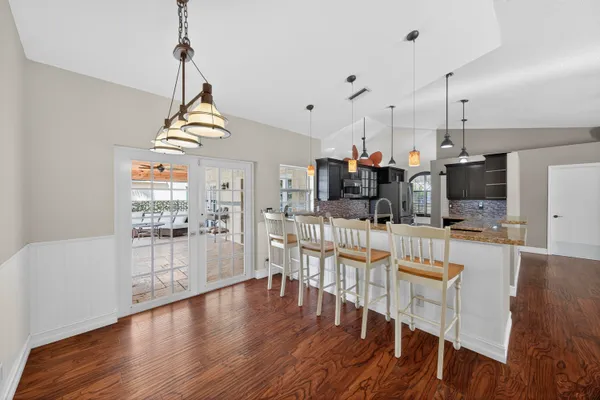 a view of a dining room and livingroom with furniture wooden floor a chandelier