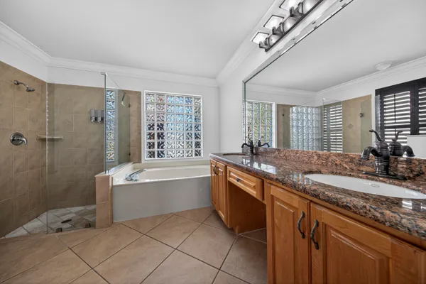a large bathroom with a granite countertop tub a sink and a large mirror