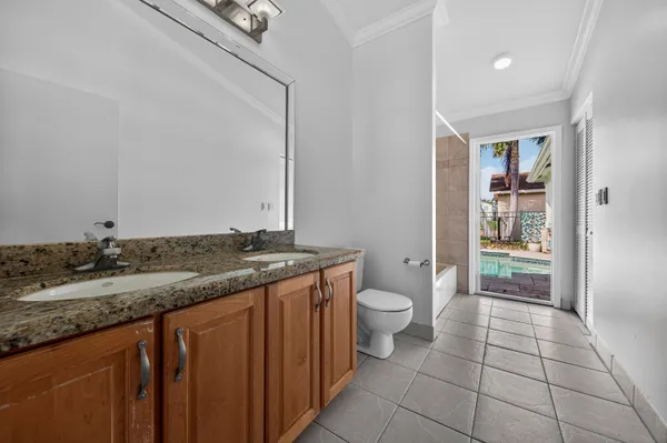 a bathroom with a granite countertop sink a toilet and a mirror