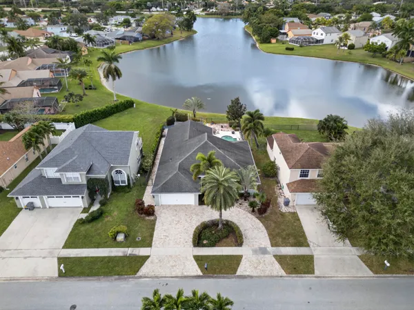 an aerial view of a house with a garden and lake view