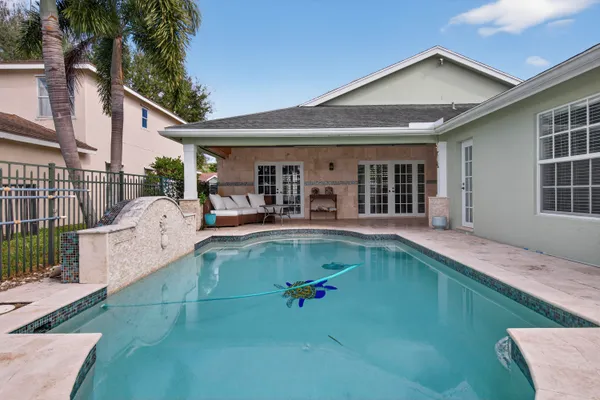 a view of a house with pool and chairs