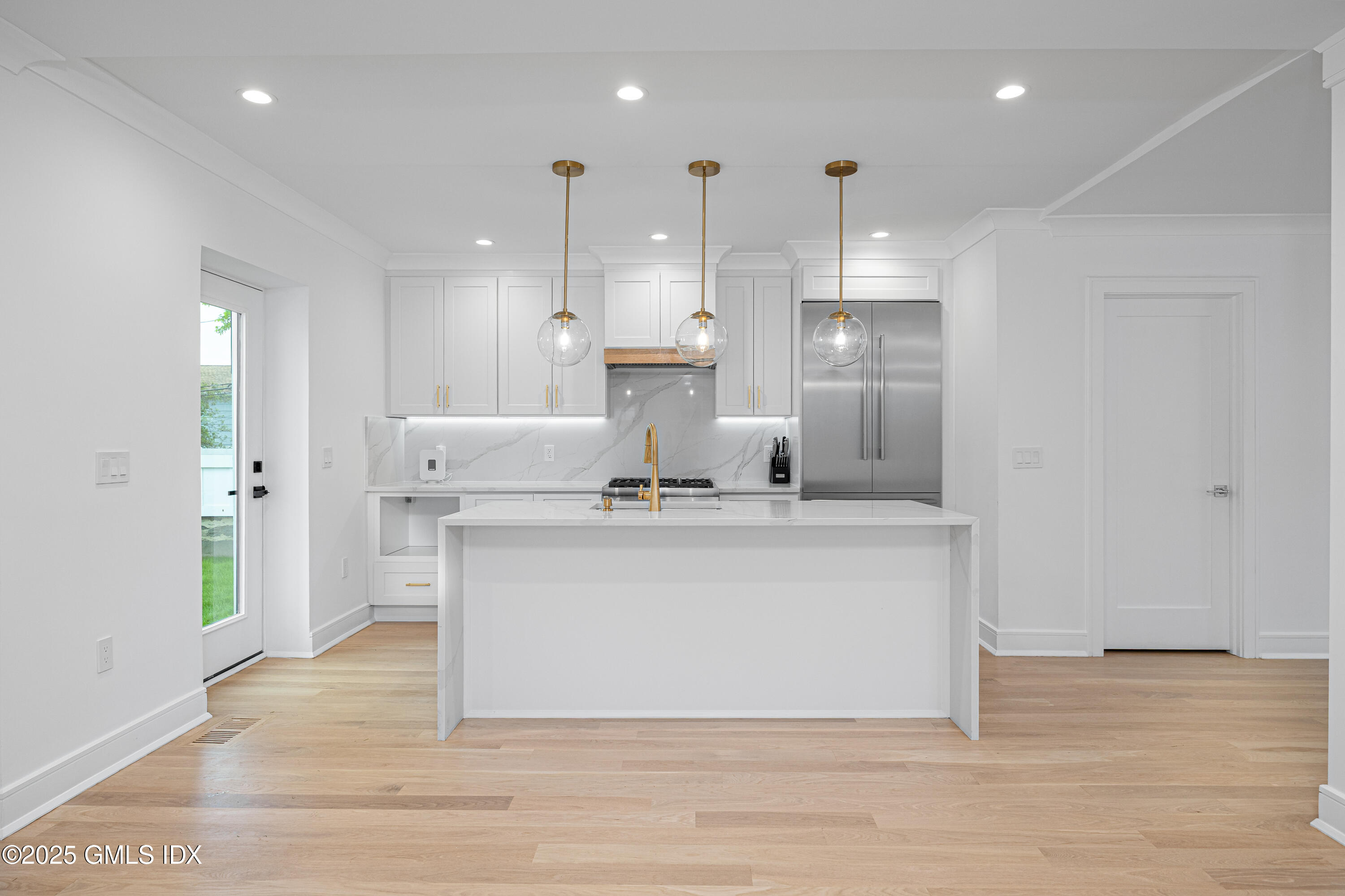 a view of kitchen with kitchen island stainless steel appliances sink refrigerator and stove