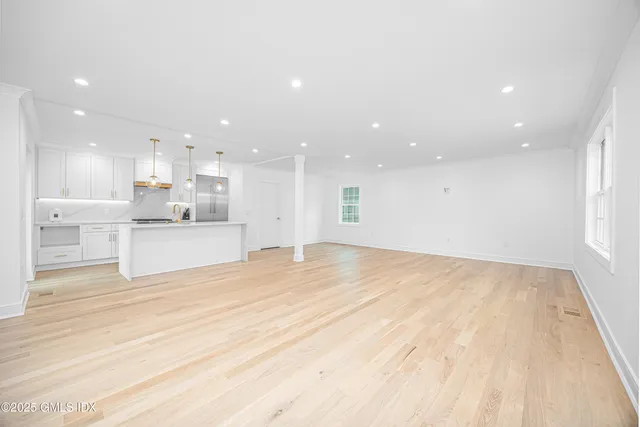 a view of a kitchen with kitchen island white cabinets and wooden floor
