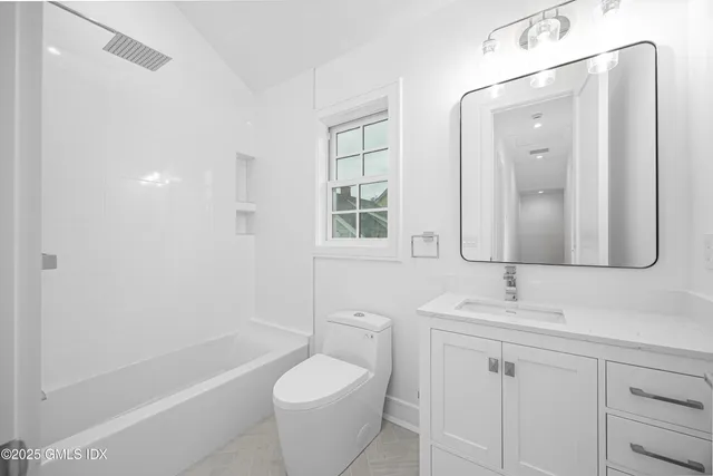 a bathroom with a double vanity sink a toilet and shower