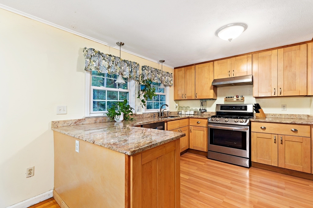 102 Turtleback Road Barnstable, MA 02648 - Photo 8 of 20 a kitchen with stainless steel appliances granite countertop a stove a sink and a microwave