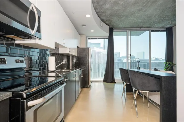 a kitchen with stainless steel appliances granite countertop a stove a sink and a refrigerator