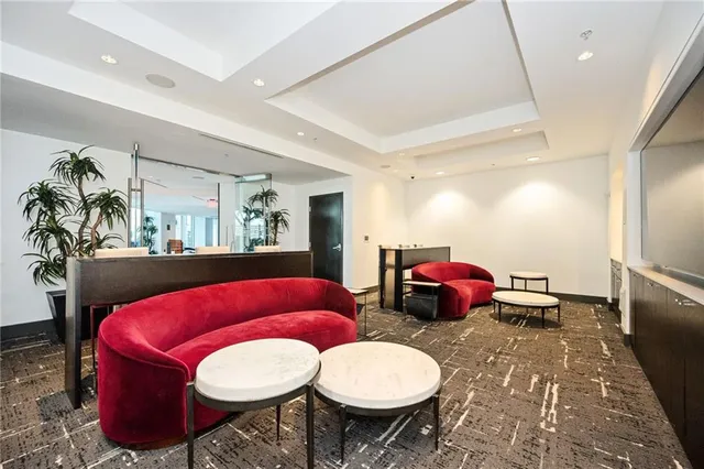 a living room with furniture a rug and white walls