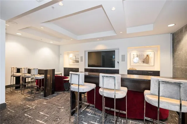 a living room with furniture a flat screen tv and kitchen view