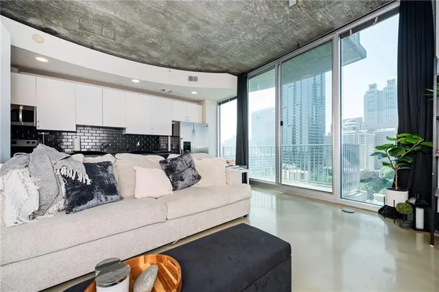 a living room with furniture flowerpot and wooden floor