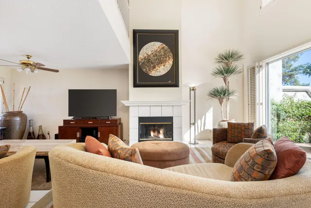 a living room with furniture a fireplace and a large mirror