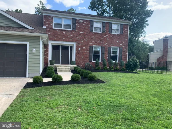 a view of a house with a yard and a large tree
