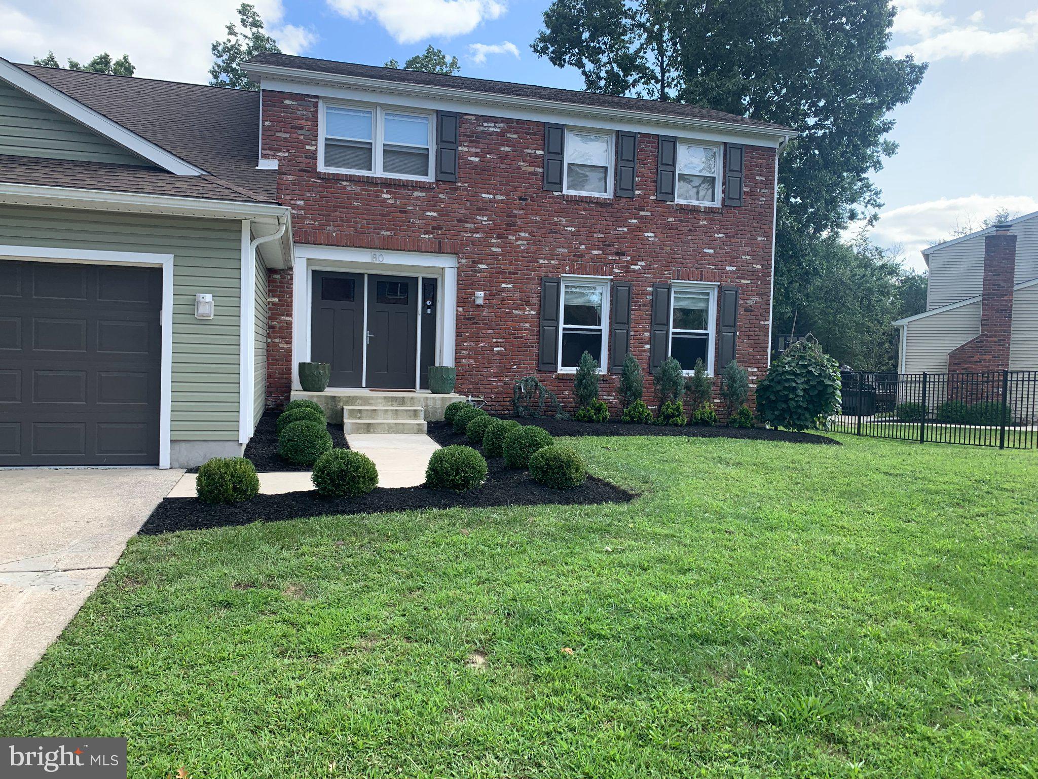 a view of a house with a yard and a large tree