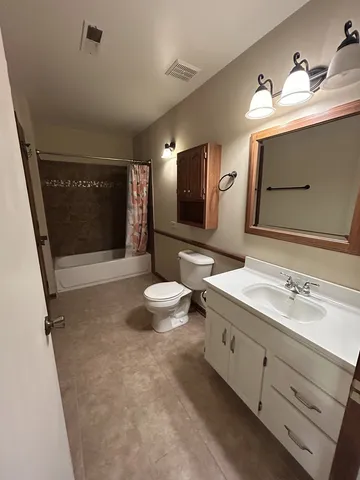 a spacious bathroom with a toilet sink and mirror