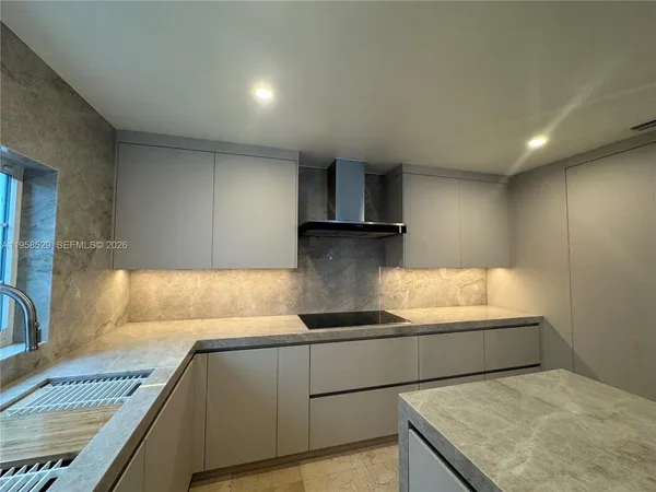 a kitchen with granite countertop a sink and a stove top oven