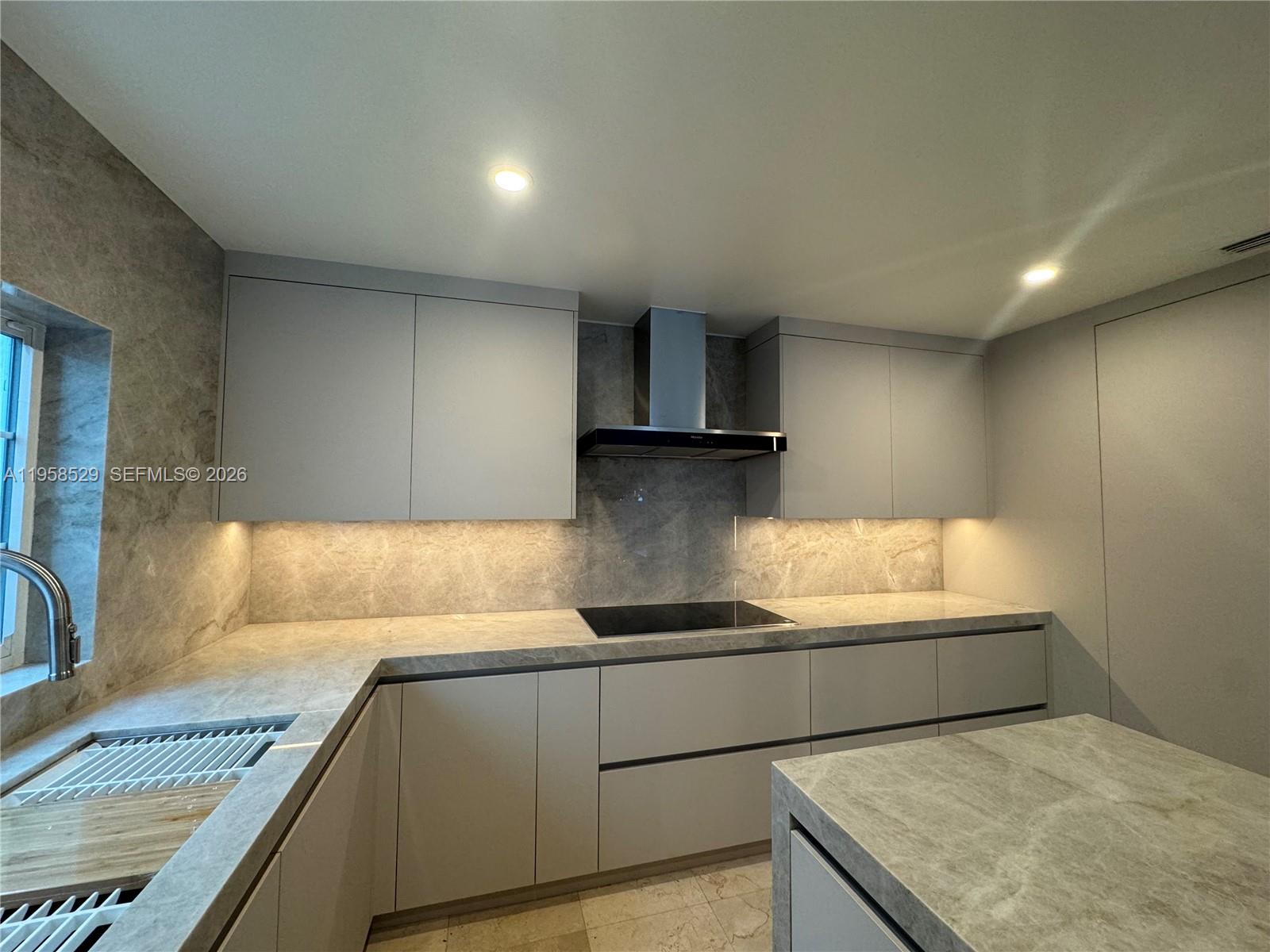 3185 Washington Street Miami, FL 33133 - Photo 2 of 48 a kitchen with granite countertop a sink and a stove top oven
